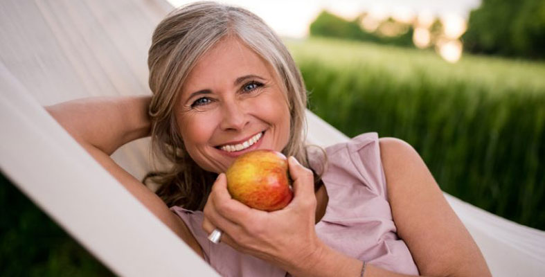 Woman Eating Apple with Dental Implants
